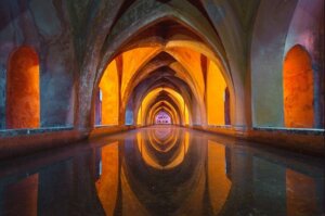 An orange and blue temple with still water covering the floor.