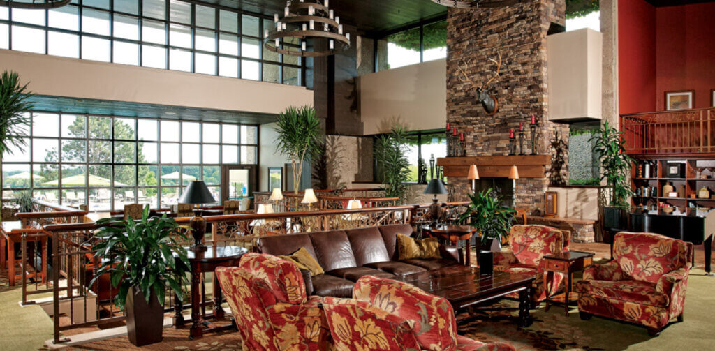 Interior view of the Grand Geneva Resort main lounge, with plush club chairs, couches, and expansive window 