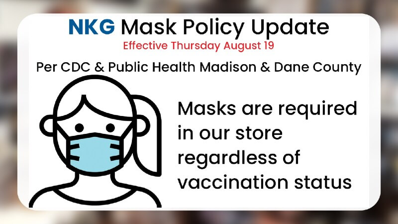 Noble Knight Games mask policy update sign showing a cartoon masked face noting that masks are required in the store regardless of vaccination status