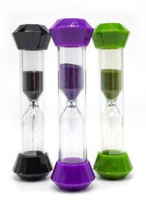 three small, plastic hourglass timers, one black, one purple, and one green