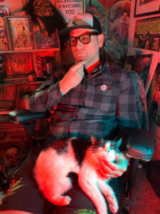 photo of skinner in thoughtful pose with cat on his lap