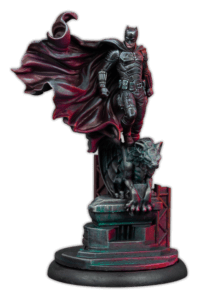 miniature model of batman standing on top of a stone gargoyle with his cape in the wind from the batman miniature game