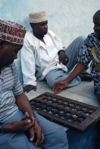 three men playing a mancala game in Mji Mkongwe, Zanzibar