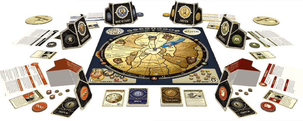 photo of board game Dune by Gale Force Nine, set up with all six original factions with the game board in the center and player tokens and cards arrayed around it in a circle